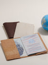 Passport holder with a passport inside, next to a globe on a light background