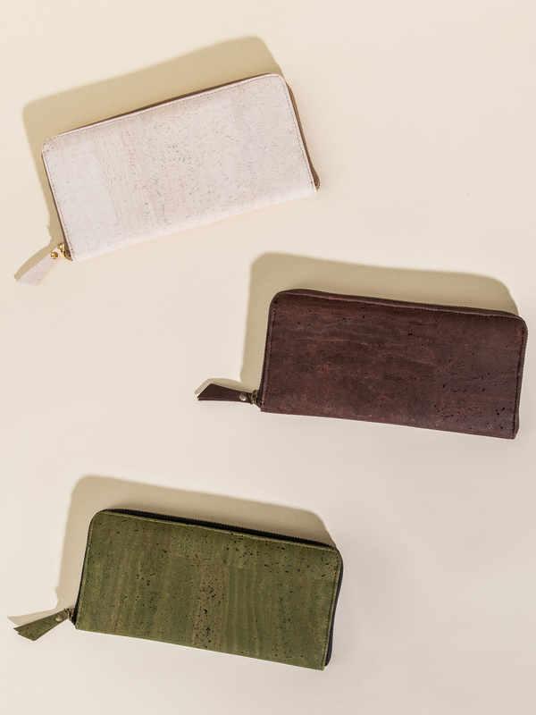 Three wallets in beige, brown, and green on a light beige background