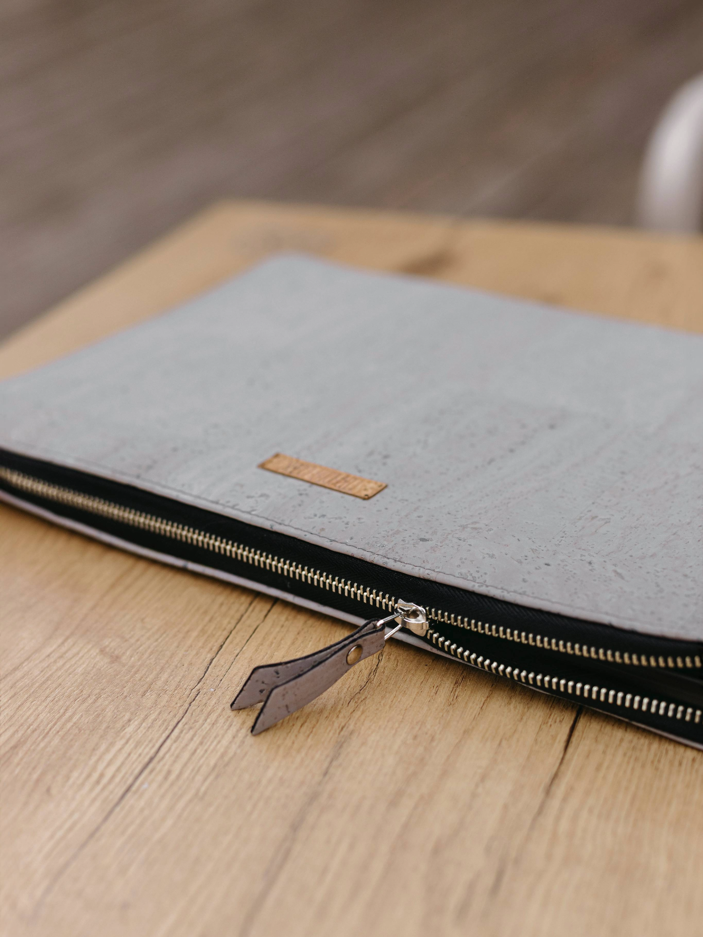 Gray laptop sleeve with zipper on a wooden surface