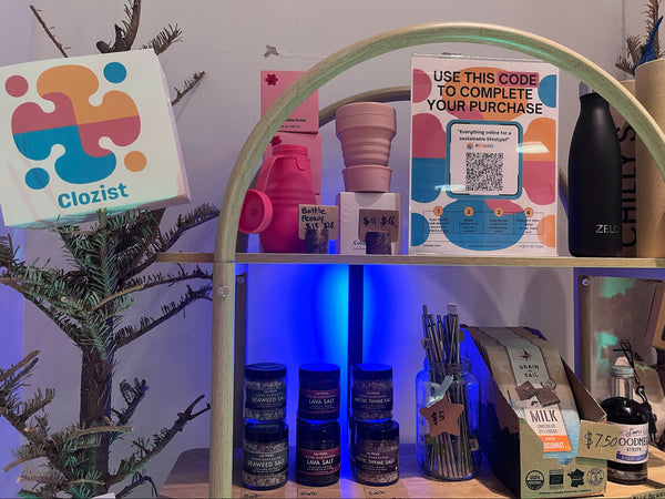 Shelf with various items including a Clozist sign, colorful boxes, and bottles.