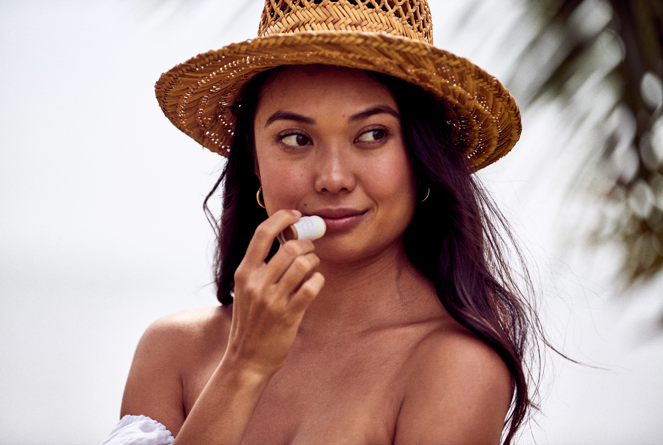 Woman applying Desesh natural vegan lip balm – sustainable plastic-free lip care made in the USA