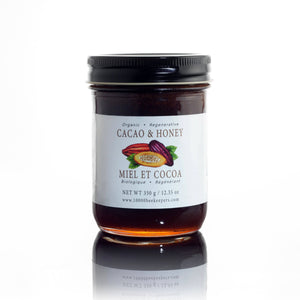 African Bronze Honey Company organic cacao nibs and honey spread in a glass jar on a white background