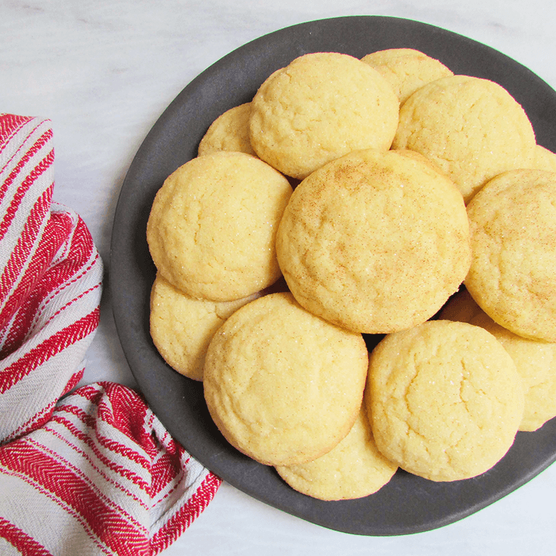 Plate of round cookies with a red and white striped towel on a light background