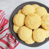 Plate of round cookies with a red and white striped towel on a light background