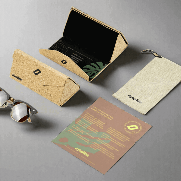 Sunglasses with cork case, pouch, and leaflet on a gray background