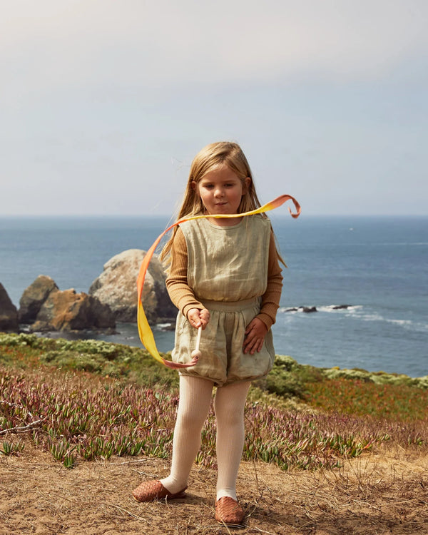 Young girl standing on a coastal cliff with ocean view