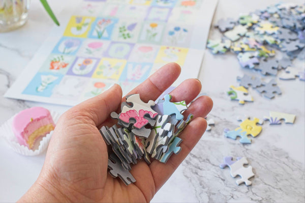 ABC Flowers puzzle pieces from Oakland Puzzle Company laid out in a lifestyle setting