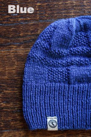 Blue knit beanie on a wooden surface with 'Blue' text above it
