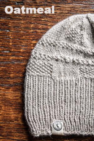 Gray knit beanie on a wooden surface with 'Oatmeal' text above