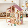 Wooden dollhouse with furniture in a decorated room with a Christmas tree.