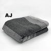 Folded gray blanket with 'AJ' branding on a white background
