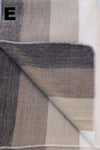 Textured fabric with a geometric pattern in shades of brown and gray on a white background.