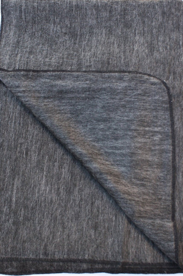 Gray fabric with a subtle pattern, possibly a blanket or towel, on a plain background.