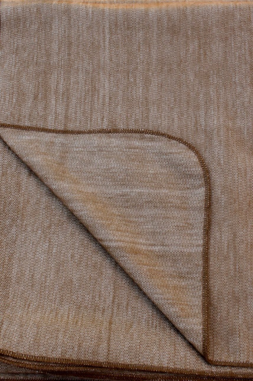 Close-up of a brown textured rug with a folded corner.