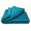 Folded teal blanket on a white background