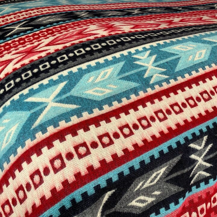 Purely Alpaca Southwest Aztec blanket styled as a bed throw, showing pattern and texture