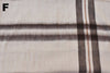 Close-up of plaid fabric with brown and beige colors on a white background.