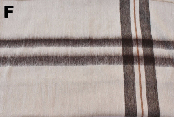 Close-up of plaid fabric with brown and beige colors on a white background.