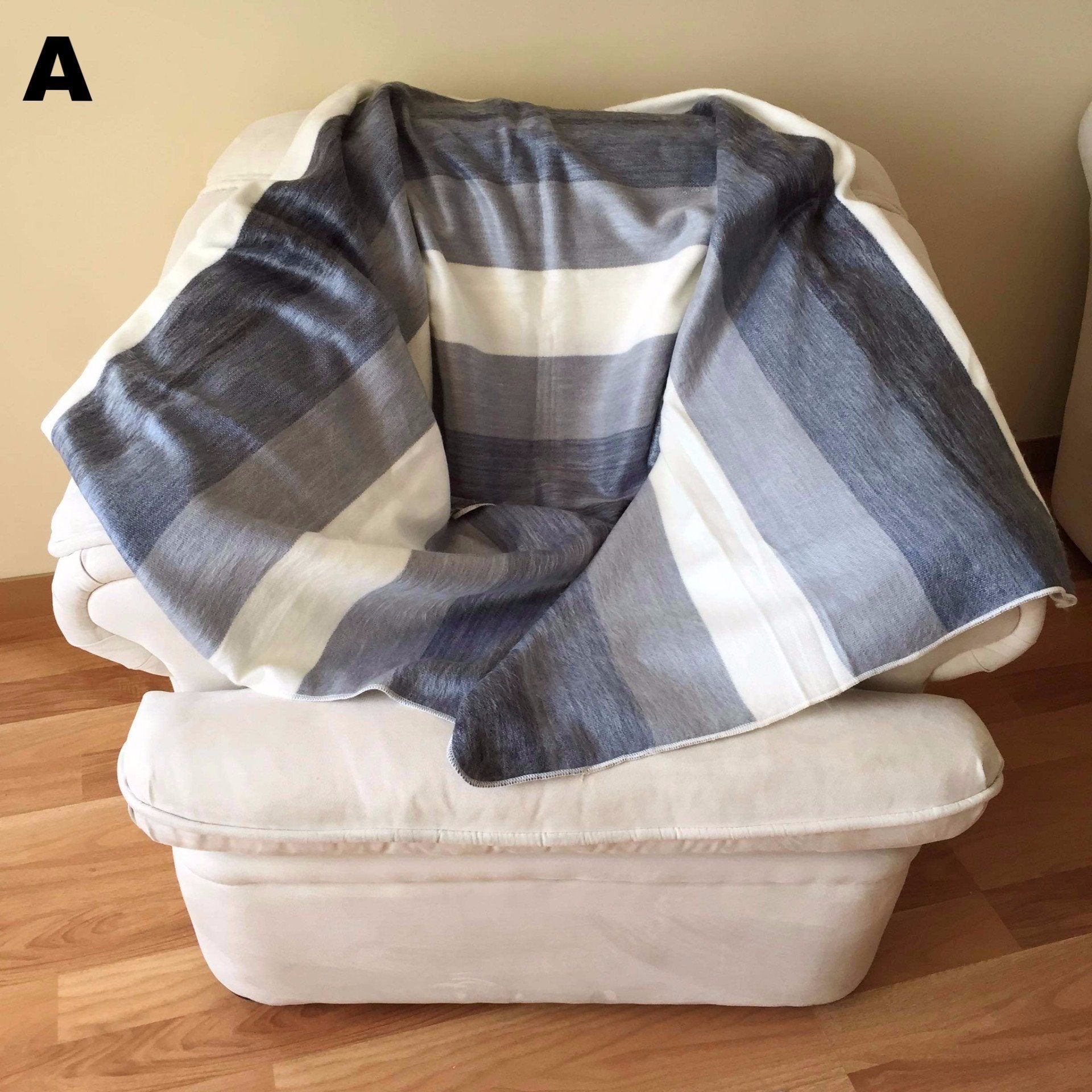 Striped alpaca throw blanket displayed on a couch, styled as a cosy living room cuddle blanket