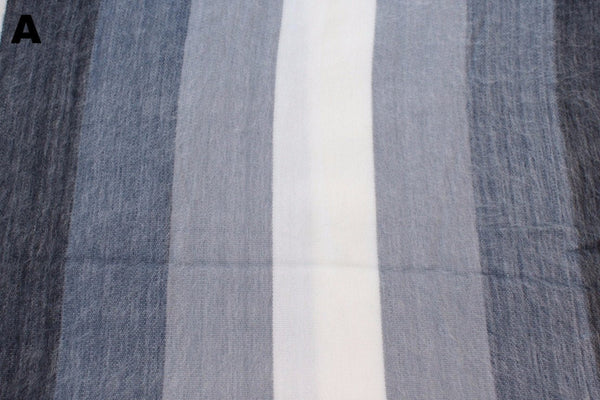 Multiple striped alpaca bed blanket colour options laid out, handcrafted in Otavalo Ecuador
