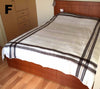 Bed with plaid blanket in a bedroom setting