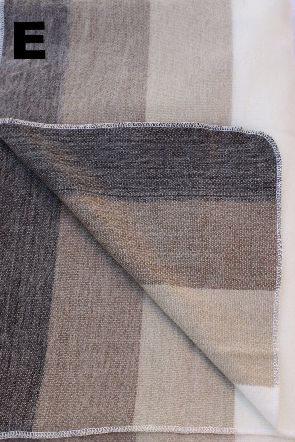 Textured fabric with a geometric pattern in shades of brown and gray on a white background.