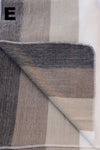 Textured fabric with a geometric pattern in shades of brown and gray on a white background.