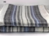 Stack of striped socks with gray, white, and blue colors on a light background.