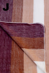 Close-up of a fabric with brown, beige, and white stripes.