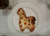 Alpaca-shaped pizza on a white plate with a glass of red wine in the background.