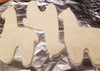 Unbaked cookie cutouts shaped like animals on a baking sheet with tinfoil.