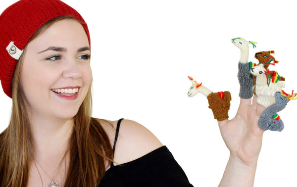 Person wearing a red beanie and holding finger puppets on a white background