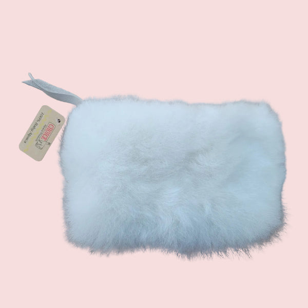 White fur pouch with a tag on a brown background