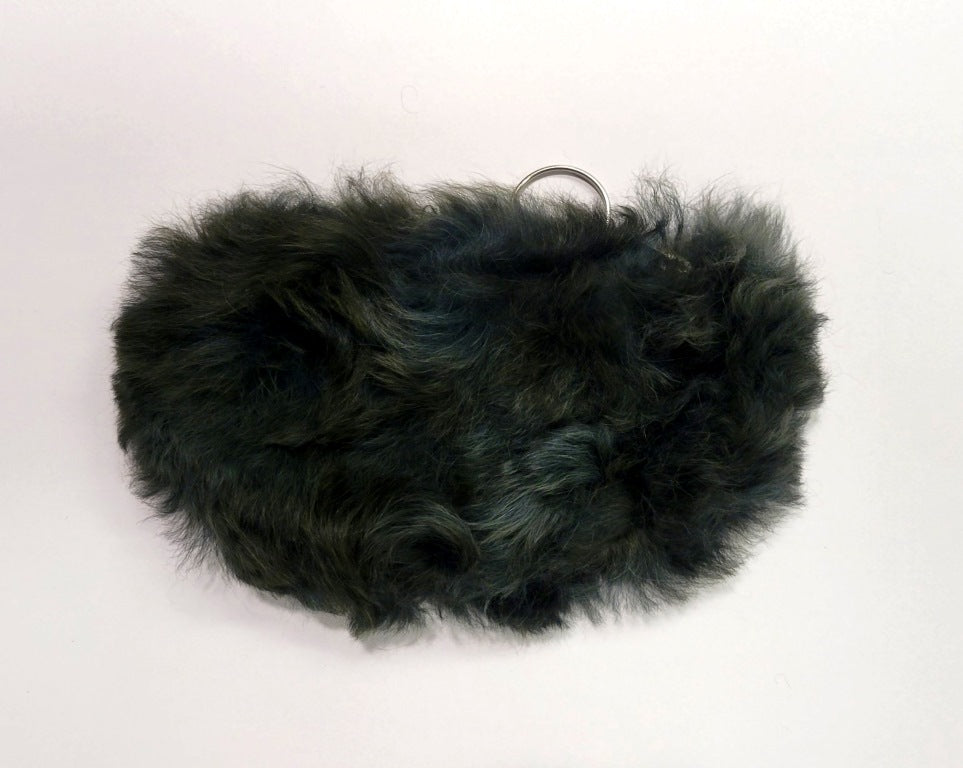 Dark green fur pouch on a white background