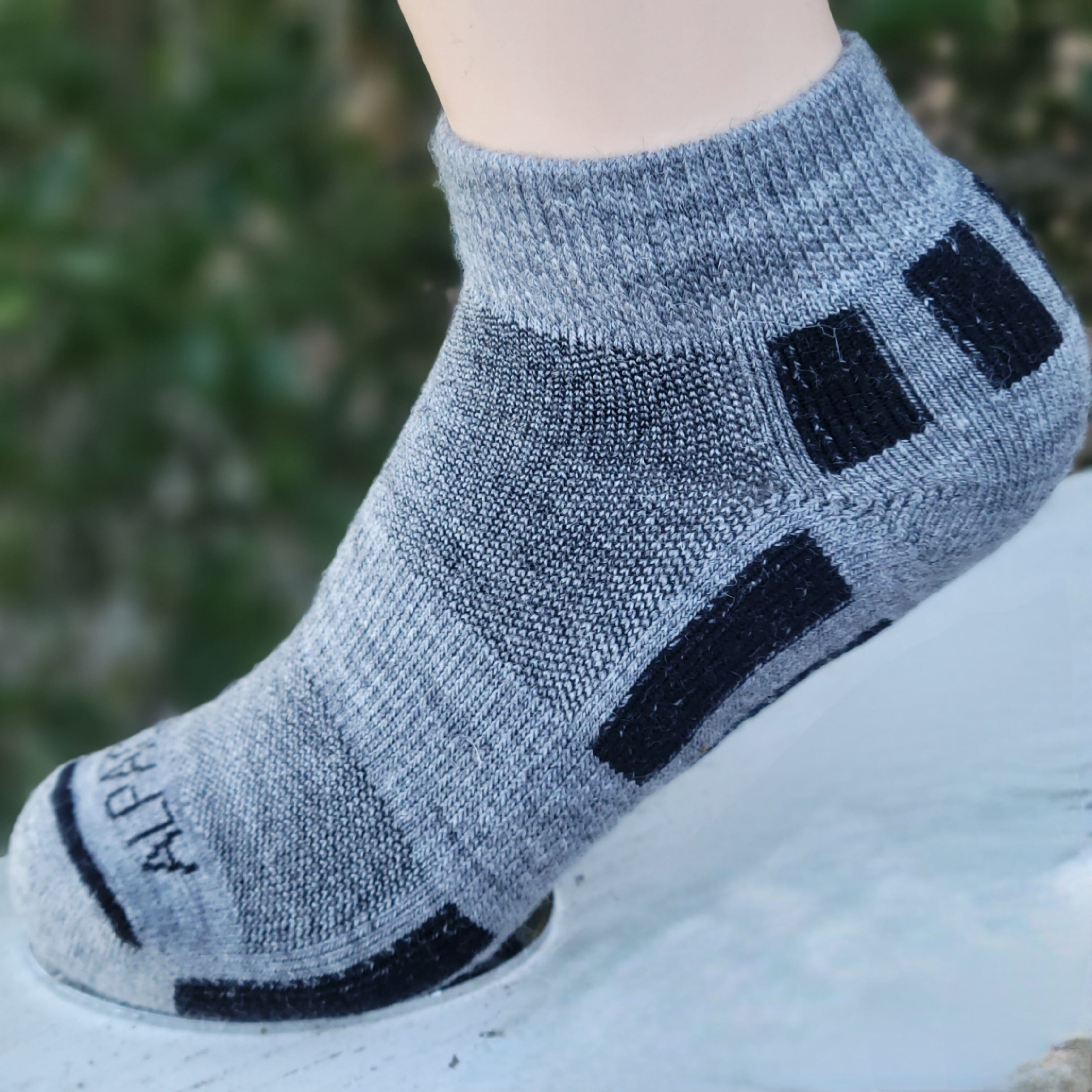 Gray ankle sock with black accents on a blurred background
