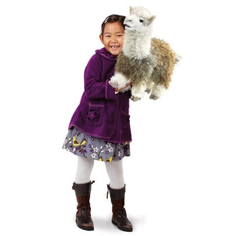 Close-up of the plush alpaca stage puppet showing detail of its soft fleece-like fabric and movable mouth