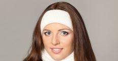 Woman wearing a white headband against a neutral background