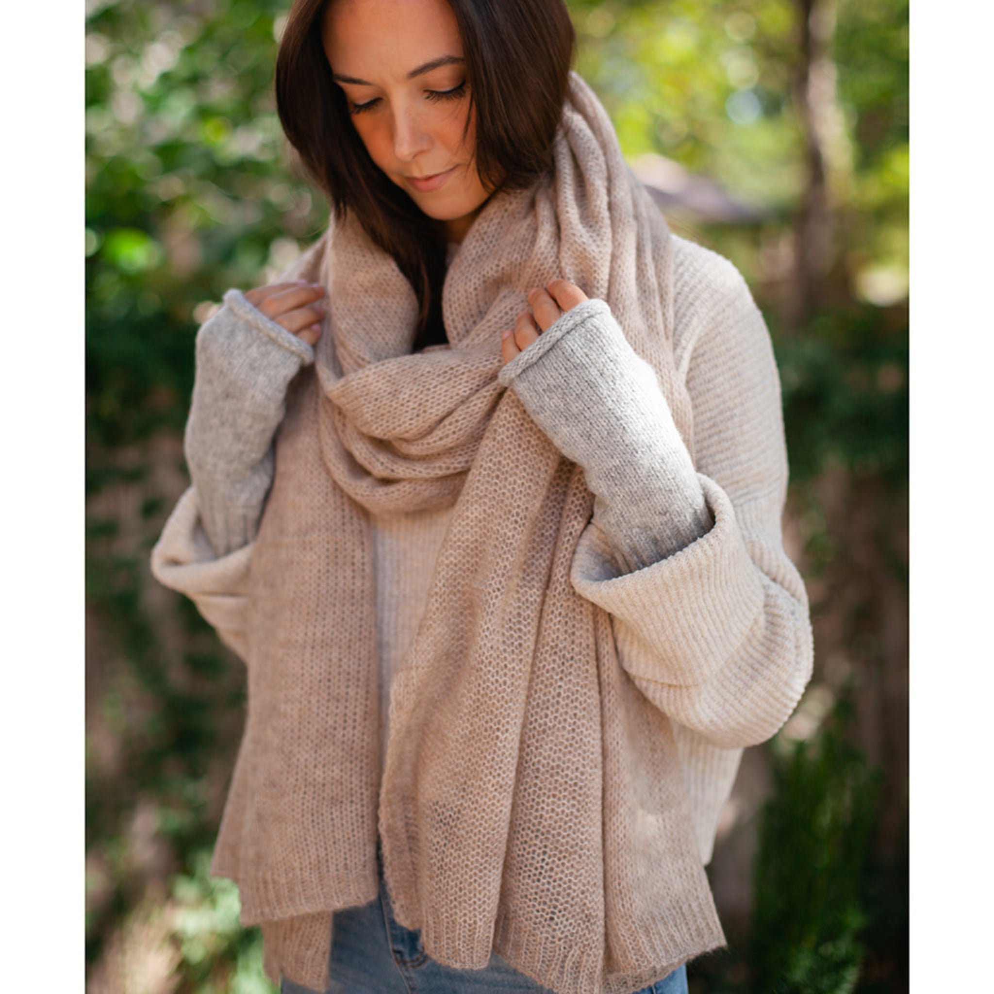 Woman wearing a beige scarf and sweater outdoors