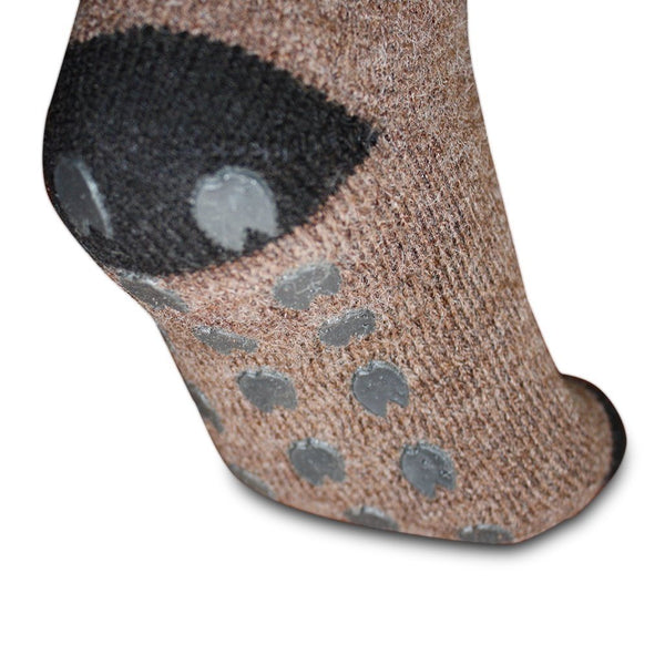 Close-up of a brown sock with gray paw prints on a white background. Stay cozy with AlpacaTrax Gripper Slipper Socks – ultra-warm, non-slip alpaca wool socks for men & women. Breathable, odor-free, durable, and machine washable. Perfect house slipper alternative.