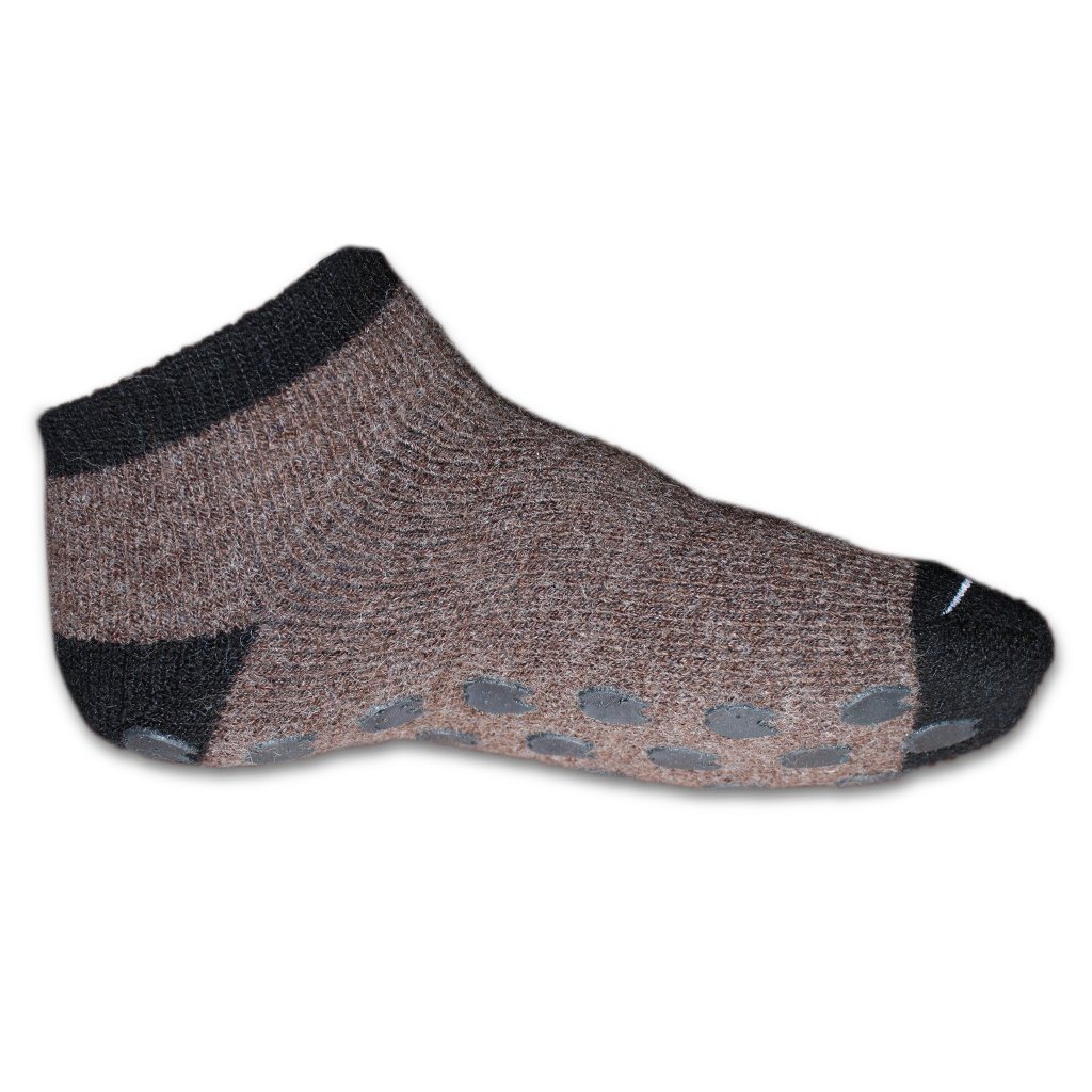 Brown sock with black toes and cuffs on a white background. Stay cozy with AlpacaTrax Gripper Slipper Socks – ultra-warm, non-slip alpaca wool socks for men & women. Breathable, odor-free, durable, and machine washable. Perfect house slipper alternative.