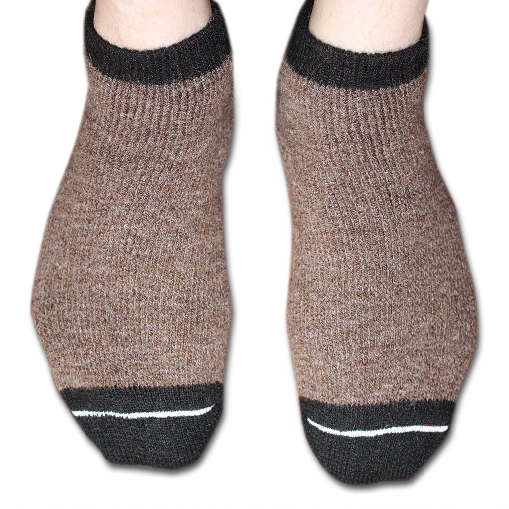 Brown socks with black cuffs and toes on a white background. Stay cozy with AlpacaTrax Gripper Slipper Socks – ultra-warm, non-slip alpaca wool socks for men & women. Breathable, odor-free, durable, and machine washable. Perfect house slipper alternative.