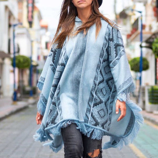 Woman wearing a blue patterned poncho on a city street