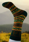 Colorful knitted sock with a pattern on a blurred natural background