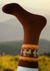 Brown sock with orange and white pattern on a blurred natural background
