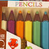 Set of colorful pencils in a box with a cartoon dinosaur character on a brown background