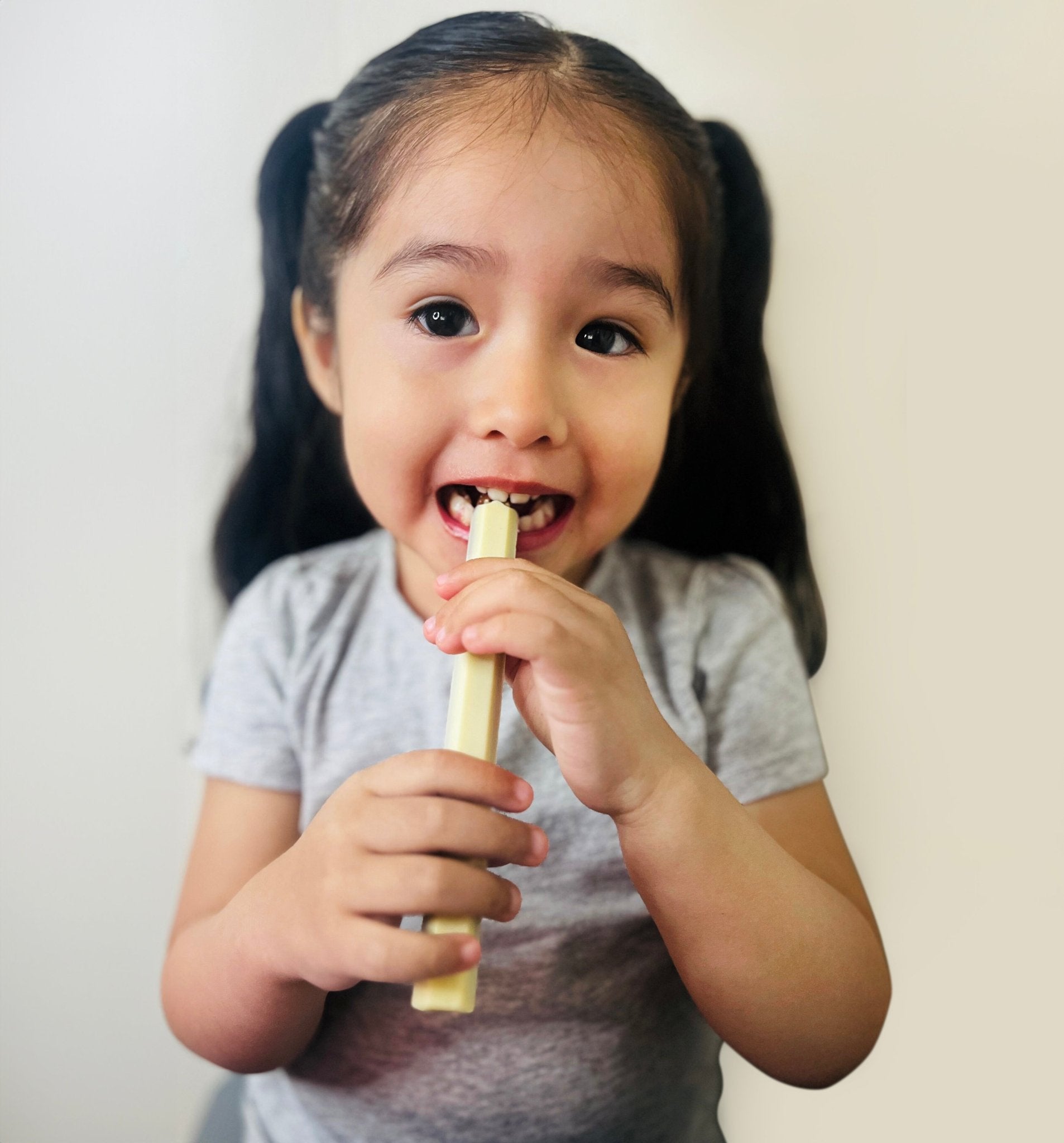 Child holding a popsicle against a plain background