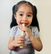 Child holding a popsicle against a plain background