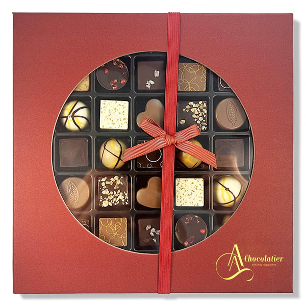 Red chocolate box with a ribbon and various chocolates inside, featuring the brand 'A Chocolatier'. Experience luxury with Andy Anand’s 25-piece Belgian Chocolate Truffle Gift Box. Handcrafted with 60% chocolate and cocoa butter, this Master Chef-curated assortment features 12 artisan flavors. The perfect gourmet gift for holidays, birthdays, and anniversaries!