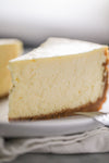 Slice of cheesecake on a white plate with a blurred background