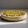 Slice of Andy Anand sugar-free gluten-free caramel pistachio cheesecake showing dense New York-style cream cheese filling